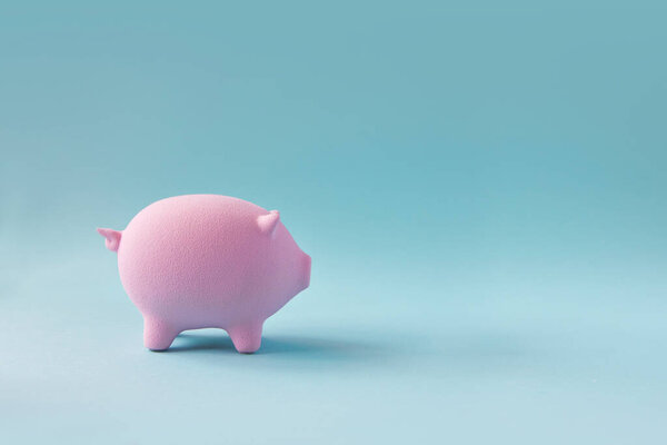 Piggy bank on blue copy space background.