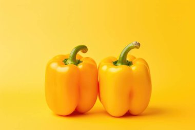 Sarı arka planda iki sarı dolma biber..