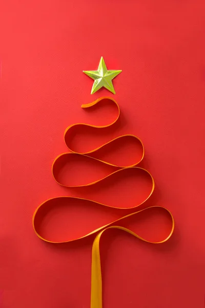 Abstract Christmas tree form by ribbon on red background.