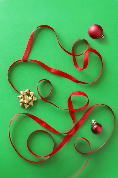 Rotes Band Und Weihnachtsschmuck Auf Grünem Hintergrund Stockfoto