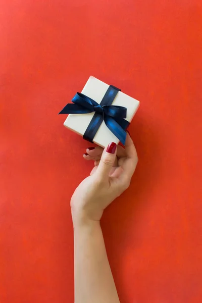 Hand Hält Eine Geschenkbox Auf Rotem Hintergrund Stockbild