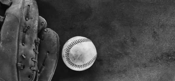 Old used baseball in sports glove closeup