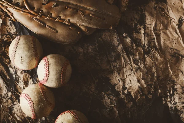 Old used baseball balls and sports glove closeup