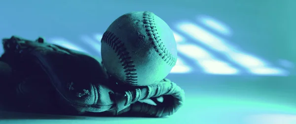 Old used baseball in sports glove closeup