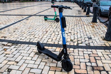 Rusya 'yla savaş sırasında Kyiv' de park etmiş bir motosiklet kiralamak için elektrikli scooter. Kyiv, Rus füzeleri ve sirenleri tarafından hedef alınsa bile insanlar onu her gün kullanıyor.