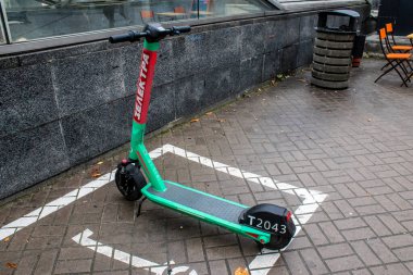 Rusya 'yla savaş sırasında Kyiv' de park etmiş bir motosiklet kiralamak için elektrikli scooter. Kyiv, Rus füzeleri ve sirenleri tarafından hedef alınsa bile insanlar onu her gün kullanıyor.