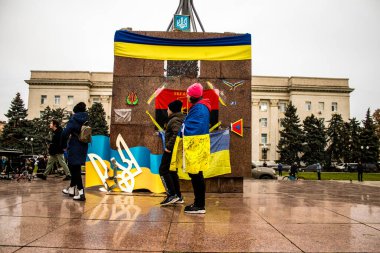 Ukrayna bayrağını pelerin şeklinde giyen bazı Kherson vatandaşları şehrin şehir merkezindeki Özgürlük Meydanı 'nda özgürlüğünü kutluyorlar. Rus birlikleri dokuz aylık bir işgal ve Ukraynalı bir karşı taarruz sonrasında Kherson 'dan ayrıldı.