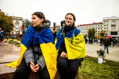 Ukrayna bayrağını pelerin şeklinde giyen bazı Kherson vatandaşları şehrin şehir merkezindeki Özgürlük Meydanı 'nda özgürlüğünü kutluyorlar. Rus birlikleri dokuz aylık bir işgal ve Ukraynalı bir karşı taarruz sonrasında Kherson 'dan ayrıldı.