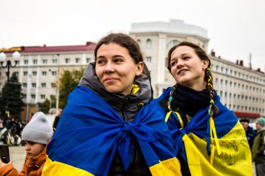 Ukrayna bayrağını pelerin şeklinde giyen bazı Kherson vatandaşları şehrin şehir merkezindeki Özgürlük Meydanı 'nda özgürlüğünü kutluyorlar. Rus birlikleri dokuz aylık bir işgal ve Ukraynalı bir karşı taarruz sonrasında Kherson 'dan ayrıldı.