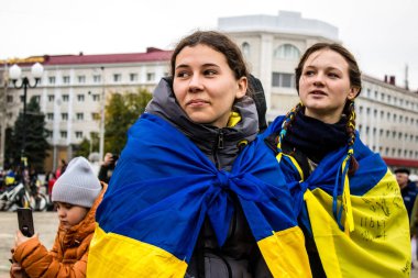 Ukrayna bayrağını pelerin şeklinde giyen bazı Kherson vatandaşları şehrin şehir merkezindeki Özgürlük Meydanı 'nda özgürlüğünü kutluyorlar. Rus birlikleri dokuz aylık bir işgal ve Ukraynalı bir karşı taarruz sonrasında Kherson 'dan ayrıldı.