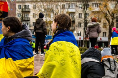 Ukrayna bayrağını pelerin şeklinde giyen bazı Kherson vatandaşları şehrin şehir merkezindeki Özgürlük Meydanı 'nda özgürlüğünü kutluyorlar. Rus birlikleri dokuz aylık bir işgal ve Ukraynalı bir karşı taarruz sonrasında Kherson 'dan ayrıldı.