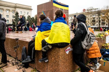 Ukrayna bayrağını pelerin şeklinde giyen bazı Kherson vatandaşları şehrin şehir merkezindeki Özgürlük Meydanı 'nda özgürlüğünü kutluyorlar. Rus birlikleri dokuz aylık bir işgal ve Ukraynalı bir karşı taarruz sonrasında Kherson 'dan ayrıldı.