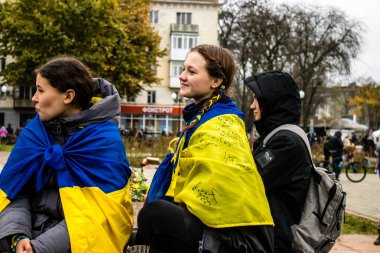 Ukrayna bayrağını pelerin şeklinde giyen bazı Kherson vatandaşları şehrin şehir merkezindeki Özgürlük Meydanı 'nda özgürlüğünü kutluyorlar. Rus birlikleri dokuz aylık bir işgal ve Ukraynalı bir karşı taarruz sonrasında Kherson 'dan ayrıldı.