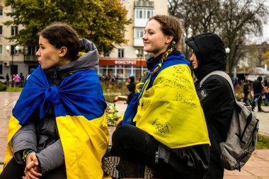 Ukrayna bayrağını pelerin şeklinde giyen bazı Kherson vatandaşları şehrin şehir merkezindeki Özgürlük Meydanı 'nda özgürlüğünü kutluyorlar. Rus birlikleri dokuz aylık bir işgal ve Ukraynalı bir karşı taarruz sonrasında Kherson 'dan ayrıldı.