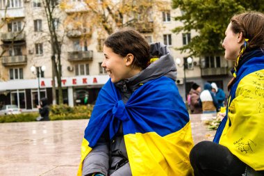 Ukrayna bayrağını pelerin şeklinde giyen bazı Kherson vatandaşları şehrin şehir merkezindeki Özgürlük Meydanı 'nda özgürlüğünü kutluyorlar. Rus birlikleri dokuz aylık bir işgal ve Ukraynalı bir karşı taarruz sonrasında Kherson 'dan ayrıldı.