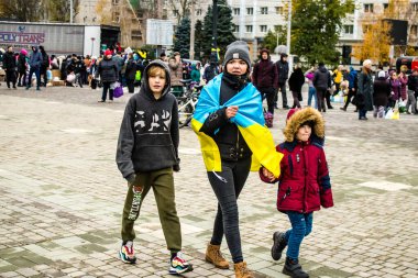 Ukrayna bayrağını pelerin şeklinde giyen bazı Kherson vatandaşları şehrin şehir merkezindeki Özgürlük Meydanı 'nda özgürlüğünü kutluyorlar. Rus birlikleri dokuz aylık bir işgal ve Ukraynalı bir karşı taarruz sonrasında Kherson 'dan ayrıldı.
