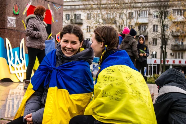 ケープの形でウクライナの旗を身に着けているカーソンのいくつかの市民は 市内中心部の自由広場に街の解放を祝います ロシア軍は9ヶ月の占領とウクライナ軍による反撃の後 カーソンを去った — ストック写真