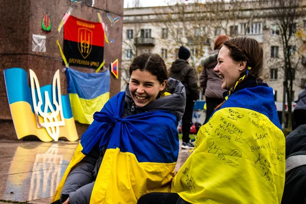 ケープの形でウクライナの旗を身に着けているカーソンのいくつかの市民は 市内中心部の自由広場に街の解放を祝います ロシア軍は9ヶ月の占領とウクライナ軍による反撃の後 カーソンを去った — ストック写真
