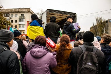 Kherson vatandaşları şehir merkezindeki Freedom Square 'de insani yardım alıyorlar. Rus birlikleri dokuz aylık işgalden ve Ukrayna ordusunun karşı saldırısından sonra Kherson 'dan ayrıldı.