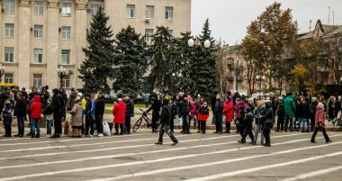 Kherson vatandaşları şehir merkezindeki Freedom Square 'de insani yardım alıyorlar. Rus birlikleri dokuz aylık işgalden ve Ukrayna ordusunun karşı saldırısından sonra Kherson 'dan ayrıldı.