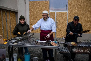 Kherson Meydanı 'nda bir lokantacı sokak mutfağı açıyor. Elektrik ve su olmamasına rağmen odun ateşiyle et pişiriyor. İnsanlar hayatlarını normal bir şekilde sürdürmek için örgütleniyorlar.