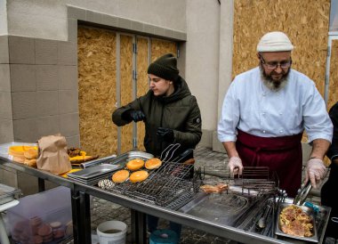 Kherson Meydanı 'nda bir lokantacı sokak mutfağı açıyor. Elektrik ve su olmamasına rağmen odun ateşiyle et pişiriyor. İnsanlar hayatlarını normal bir şekilde sürdürmek için örgütleniyorlar.