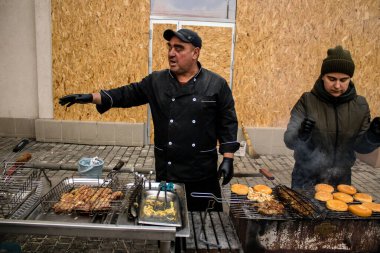 Kherson Meydanı 'nda bir lokantacı sokak mutfağı açıyor. Elektrik ve su olmamasına rağmen odun ateşiyle et pişiriyor. İnsanlar hayatlarını normal bir şekilde sürdürmek için örgütleniyorlar.