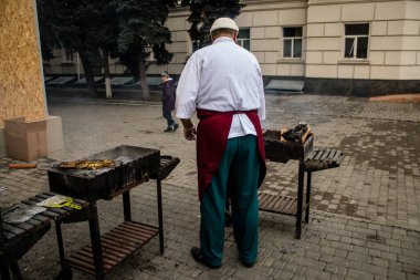 Kherson Meydanı 'nda bir lokantacı sokak mutfağı açıyor. Elektrik ve su olmamasına rağmen odun ateşiyle et pişiriyor. İnsanlar hayatlarını normal bir şekilde sürdürmek için örgütleniyorlar.