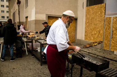 Kherson Meydanı 'nda bir lokantacı sokak mutfağı açıyor. Elektrik ve su olmamasına rağmen odun ateşiyle et pişiriyor. İnsanlar hayatlarını normal bir şekilde sürdürmek için örgütleniyorlar.