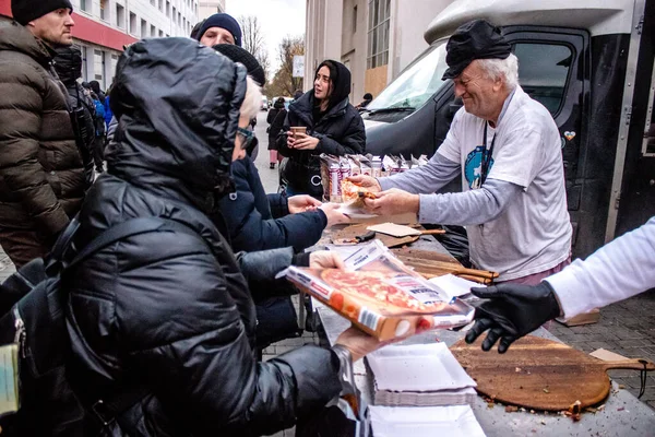 stock image An international volunteer organization cooks and delivers pizza to the residents of Kherson in the main square in the city center. Many humanitarian aid provide their support in food or clothing to people who lack everything