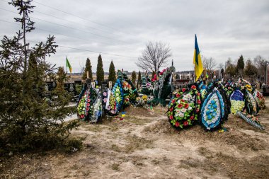 Irpin Savaşı 'nda ölen Ukraynalı askerlerin süslü mezarları. Kahramanları mezarlığın onlar için ayrılmış bir bölümüne gömüldü. Mezarlar aileler ve şehir sakinleri tarafından korunuyor.