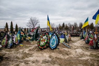Irpin Savaşı 'nda ölen Ukraynalı askerlerin süslü mezarları. Kahramanları mezarlığın onlar için ayrılmış bir bölümüne gömüldü. Mezarlar aileler ve şehir sakinleri tarafından korunuyor.