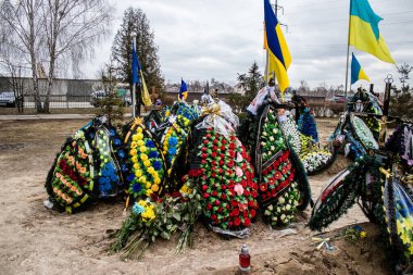 Irpin Savaşı 'nda ölen Ukraynalı askerlerin süslü mezarları. Kahramanları mezarlığın onlar için ayrılmış bir bölümüne gömüldü. Mezarlar aileler ve şehir sakinleri tarafından korunuyor.