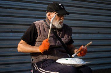 Eski bir Ukraynalı sokak müzisyeni ve ev yapımı davulu ana cadde Kherson 'da çalarken Rus ordusu şehri bombaladı..