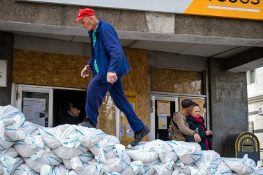 Siviller, Kherson şehir merkezinde Rus bombardımanının yol açtığı şarapnellerden korunmak için kum torbalarıyla koruyucu bir duvar örüyorlar. Bu korunma yöntemi basit ama çok etkilidir..