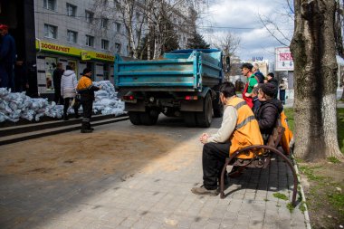 Siviller, Kherson şehir merkezinde Rus bombardımanının yol açtığı şarapnellerden korunmak için kum torbalarıyla koruyucu bir duvar örüyorlar. Bu korunma yöntemi basit ama çok etkilidir..