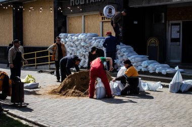 Siviller, Kherson şehir merkezinde Rus bombardımanının yol açtığı şarapnellerden korunmak için kum torbalarıyla koruyucu bir duvar örüyorlar. Bu korunma yöntemi basit ama çok etkilidir..