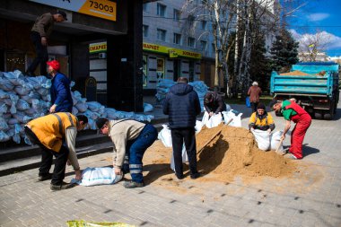 Siviller, Kherson şehir merkezinde Rus bombardımanının yol açtığı şarapnellerden korunmak için kum torbalarıyla koruyucu bir duvar örüyorlar. Bu korunma yöntemi basit ama çok etkilidir..