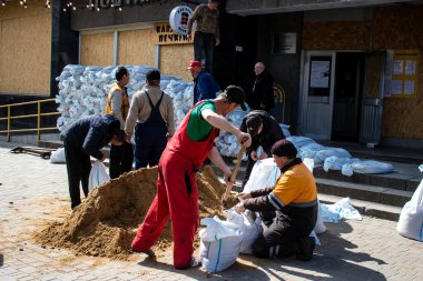 Siviller, Kherson şehir merkezinde Rus bombardımanının yol açtığı şarapnellerden korunmak için kum torbalarıyla koruyucu bir duvar örüyorlar. Bu korunma yöntemi basit ama çok etkilidir..