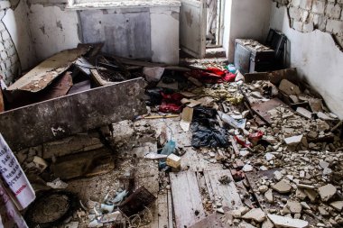 Rus bombardımanı sonucu yıkılan bir evin içi. Günlük yaşamın nesneleri farklı oturma odalarının molozlarını kirletiyor. Donbas 'taki Terne köyü bir savaş alanıdır. Tüm siviller tahliye edilmiştir.