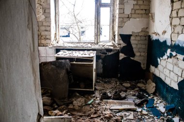 Rus bombardımanı sonucu yıkılan bir evin içi. Günlük yaşamın nesneleri farklı oturma odalarının molozlarını kirletiyor. Donbas 'taki Terne köyü bir savaş alanıdır. Tüm siviller tahliye edilmiştir.