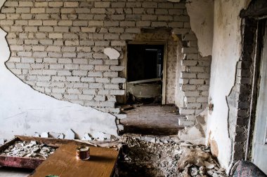 Rus bombardımanı sonucu yıkılan bir evin içi. Günlük yaşamın nesneleri farklı oturma odalarının molozlarını kirletiyor. Donbas 'taki Terne köyü bir savaş alanıdır. Tüm siviller tahliye edilmiştir.