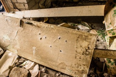 Rus bombardımanı sonucu yıkılan bir evin içi. Günlük yaşamın nesneleri farklı oturma odalarının molozlarını kirletiyor. Donbas 'taki Terne köyü bir savaş alanıdır. Tüm siviller tahliye edilmiştir.