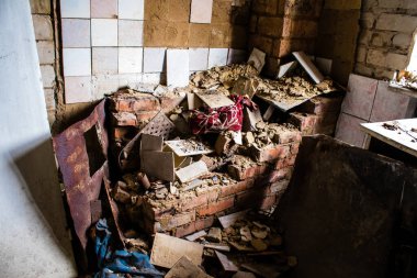 Rus bombardımanı sonucu yıkılan bir evin içi. Günlük yaşamın nesneleri farklı oturma odalarının molozlarını kirletiyor. Donbas 'taki Terne köyü bir savaş alanıdır. Tüm siviller tahliye edilmiştir.