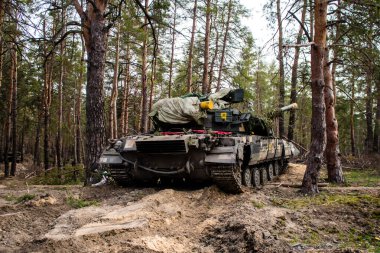 Ukrayna T-72B tankı, Donbas 'ın ön cephesi yakınlarındaki Lyman ormanında kamufle oldu. Tanklar savaş alanında gereklidir ve kendi taraflarında siper alabilen piyade askerlerine koruma sağlar..