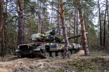 Ukrayna T-72B tankı, Donbas 'ın ön cephesi yakınlarındaki Lyman ormanında kamufle oldu. Tanklar savaş alanında gereklidir ve kendi taraflarında siper alabilen piyade askerlerine koruma sağlar..