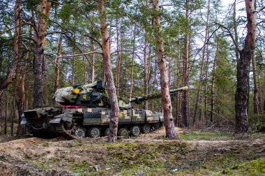 Ukrayna T-72B tankı, Donbas 'ın ön cephesi yakınlarındaki Lyman ormanında kamufle oldu. Tanklar savaş alanında gereklidir ve kendi taraflarında siper alabilen piyade askerlerine koruma sağlar..