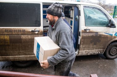 İnsanlar ambulanstan kutular dolusu erzak indiriyor.