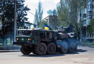 Sloviansk, Ukrayna - 26 Nisan 2023 Ukraynalı bir ordu kamyonu kendi kendine itilen bir havan topu, tekerlekli bir topçu sistemi taşıyor. Bunlar yüksek derecede hareket kabiliyetine sahipler ve bu da çekilen havan toplarına karşı başlıca avantajları.. 