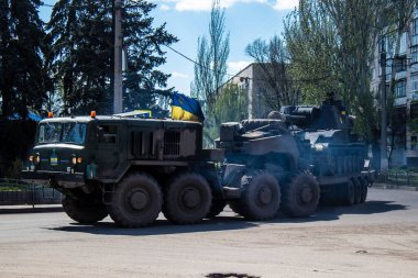 Sloviansk, Ukrayna - 26 Nisan 2023 Ukraynalı bir ordu kamyonu kendi kendine itilen bir havan topu, tekerlekli bir topçu sistemi taşıyor. Bunlar yüksek derecede hareket kabiliyetine sahipler ve bu da çekilen havan toplarına karşı başlıca avantajları.. 